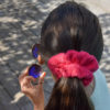 Chouchou en éponge fuchsia, un accessoire tendance des années 90 pour vos coiffures d’été.