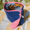 Pochette de voyage EIDA avec motif wax vibrant, fermeture éclair flashy et pompon artisanal marocain