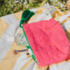 Pochette en tissu éponge avec doublure wax du Sénégal et pompon en laine du Maroc